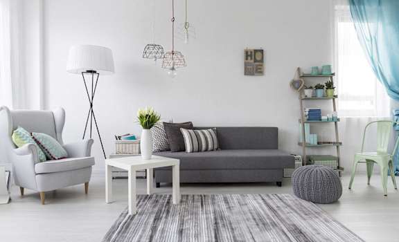 a living room with grey furniture and a gray rug