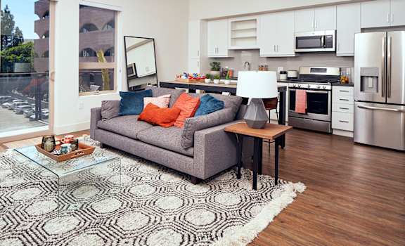 A modern living room with a grey couch and a coffee table. at Main+Nine, Riverside, 92501