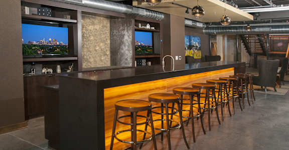 A bar with a row of stools in front of it.