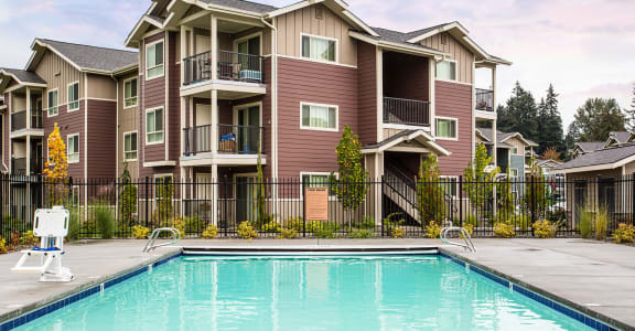 Pool with lounge chairs and apt buildings Vancouver, WA 98684 | Copper Lane Apartments