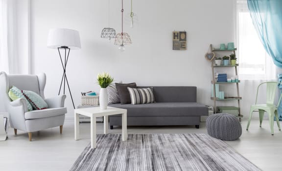 a living room with a grey couch and a white coffee table