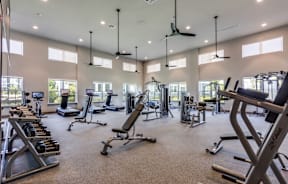 A spacious gym with a variety of equipment and a large mirror on the wall.