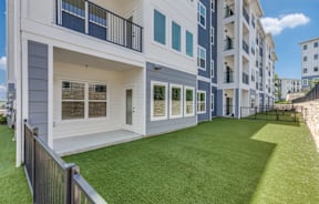 A modern apartment building with a green lawn in front.