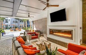 A patio with a fireplace and a television mounted on the wall.