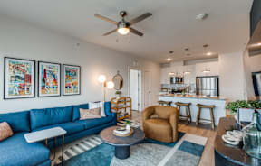 A living room with a blue couch and a ceiling fan.