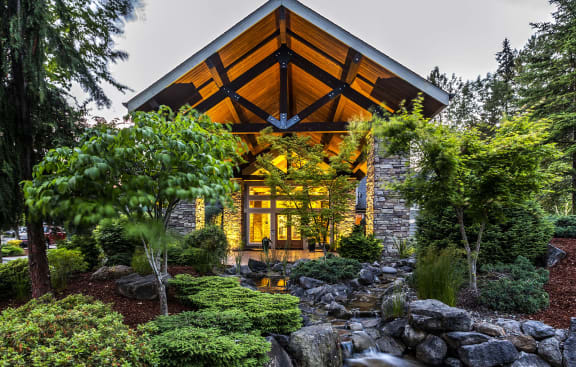 a home in the woods with a stone and wood exterior