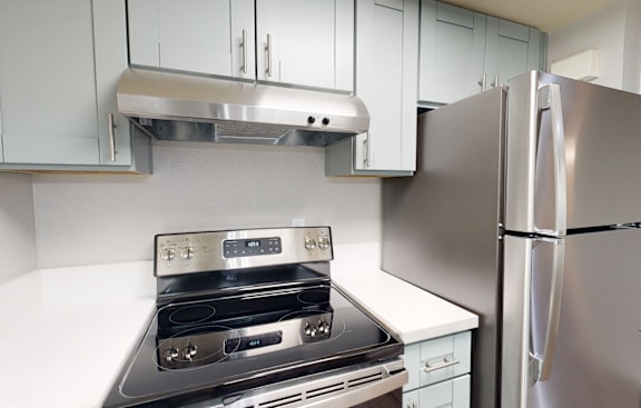 a kitchen with white cabinets and stainless steel appliances