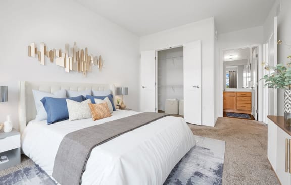 a white bedroom with a large bed and a bathroom at 1500 Nicollet Apartment Homes, Minnesota