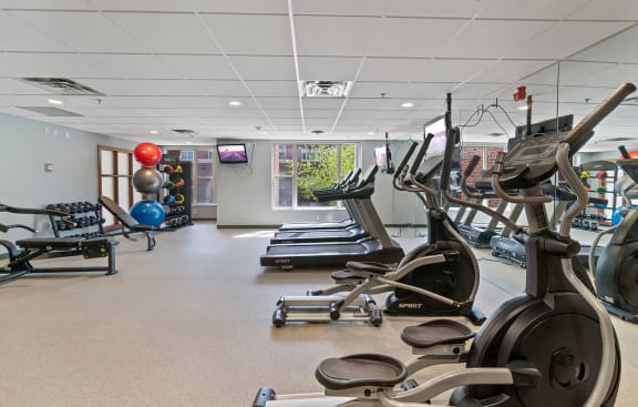 a gym with treadmills and other exercise equipment and a ball on the floor at 808 Berry Place, Saint Paul, MN 55114