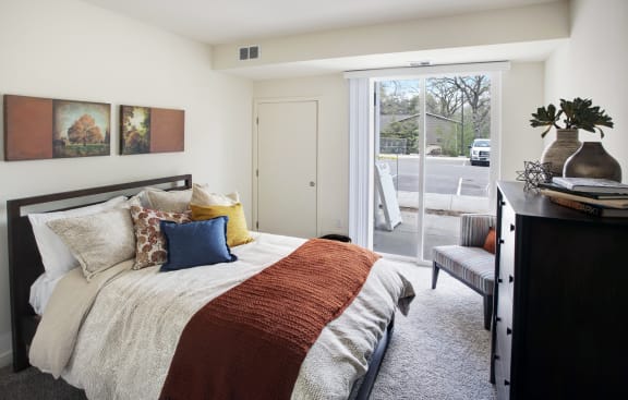 a bedroom with a bed and a door to a patio at Landings of Lexington, Lexington Minnesota