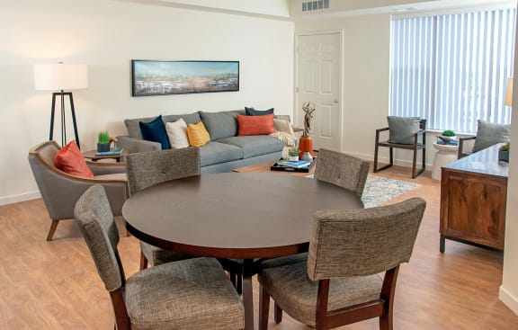 a living room and dining room with a couch and a table at The Legends of Woodbury 55+ Apartments, Woodbury Minnesota