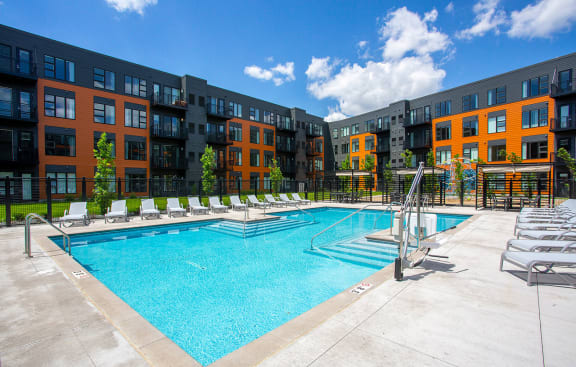 a swimming pool with an apartment building in the background at Union Flats, St. Paul, MN 55114