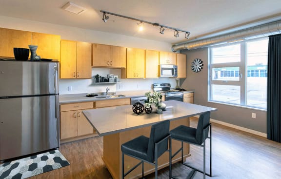 a kitchen with a large island and a stainless steel refrigerator at Union Flats, St. Paul, MN 55114
