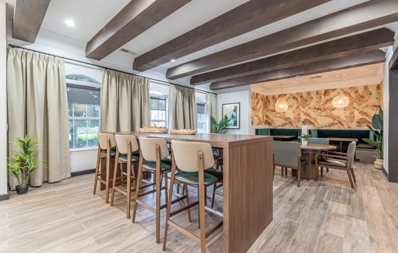 a dining area with chairs and a bar and windows at Alexander at Stonecrest Apartments, Lithonia