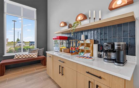A kitchen with a bench and a window overlooking a street.