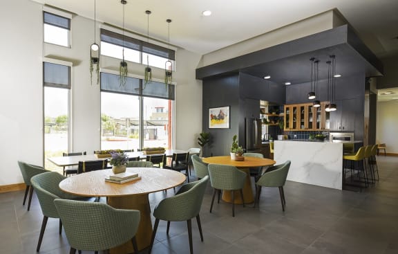 a dining room with tables and chairs and a kitchen at Aviara Flats, Phoenix, 85035