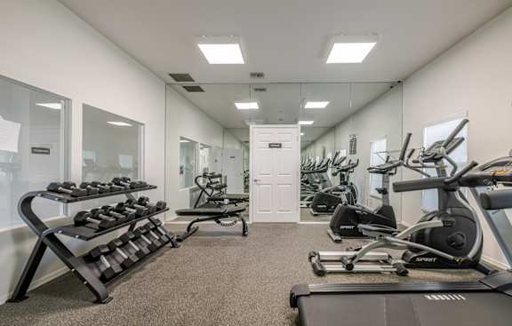 A spacious gym with a variety of equipment including treadmills, weights, and exercise machines.