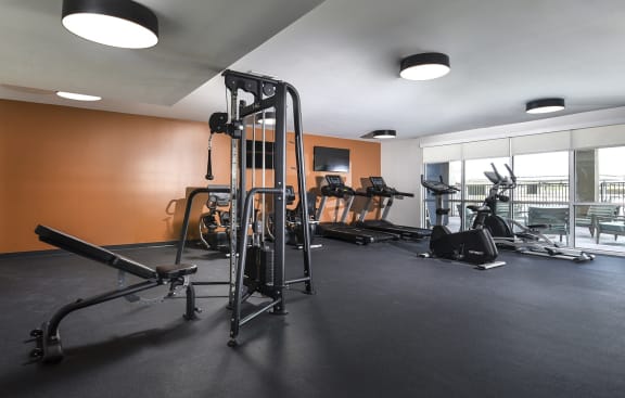 a rendering of a gym with people exercising on treadmills at Juniper Square 55+ Apartments, Arizona