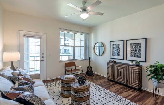 an open living room with a couch and a ceiling fan at Mission at Baytown, Baytown, TX 77521