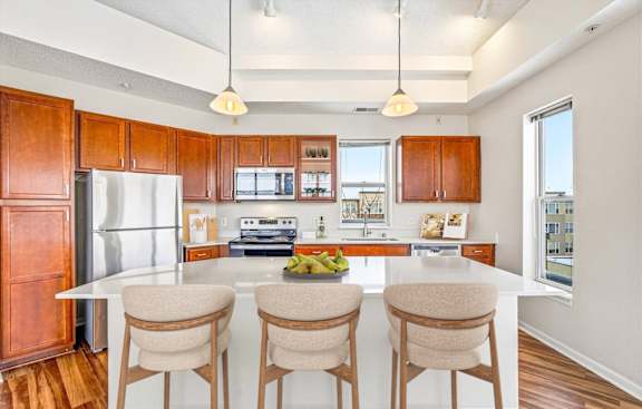 A kitchen with a white countertop and wooden cabinets.