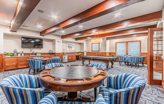 a game room with tables and chairs and a television at Mariposa at Spring Hollow Saginaw 55+ Apartments, Saginaw Texas