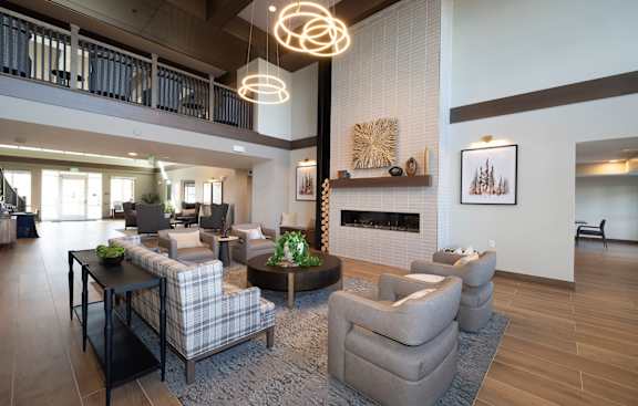 A modern living room with a fireplace and a large grey sofa.