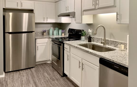 a kitchen with white cabinets and stainless steel appliances
