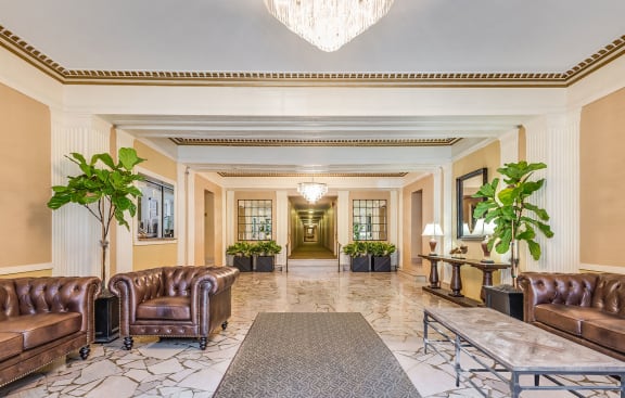 A spacious lobby with brown leather furniture and a chandelier at The Chalfonte Apartments, Washington, DC, 20009