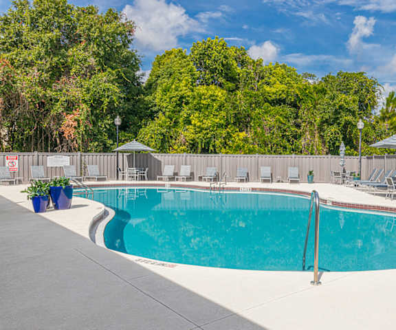 a swimming pool with chairs and umbrellas at the resort