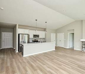 A spacious living room with a fireplace and hardwood floors. at Two Rivers Home Rentals, West Des Moines, Iowa