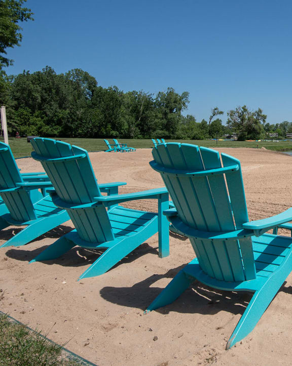 a group of blue beach chairs sitting on the beach