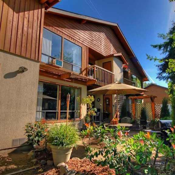 A house with a brown wooden exterior and a balcony.