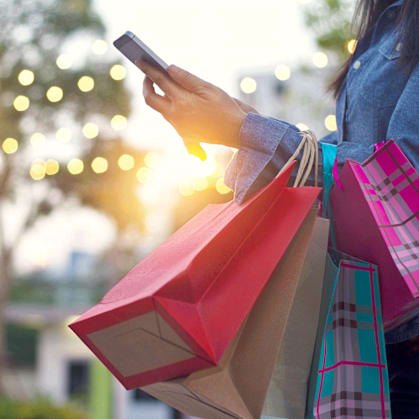 a woman holding shopping bags at Village Greens of Queen Creek