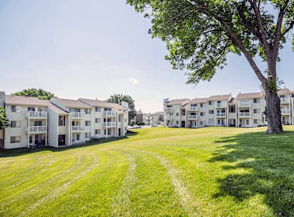A large grassy area in front of apartment buildings.