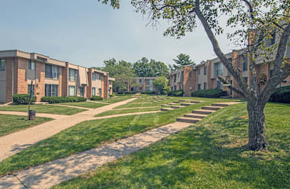 a pathway lined with apartment buildings on a sunny day