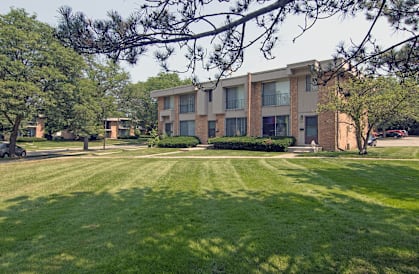 A large grassy area in front of an apartment building.