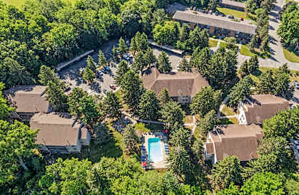 A bird's eye view of a residential area with houses and a swimming pool.