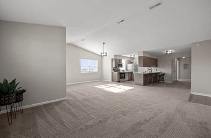 the living room and kitchen of an empty apartment