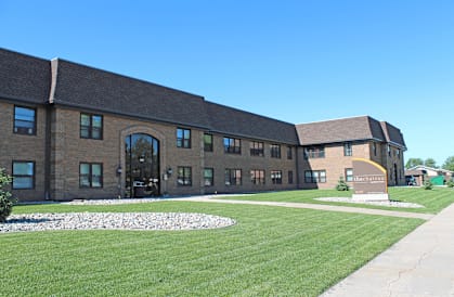 a large brick building with a grassy area in front of it