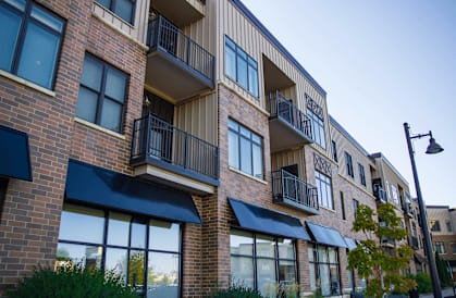 a brick apartment building with black awnings