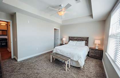 A bedroom with a bed, nightstands, and a ceiling fan.