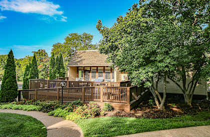 A house with a brown fence and a green lawn.