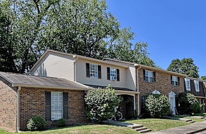 A row of houses with green trees in the background.