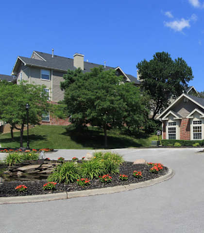 A large house with a driveway and a garden in front.