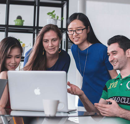 a group of people looking at a laptop computer