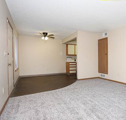 A room with a ceiling fan and carpeted floor.