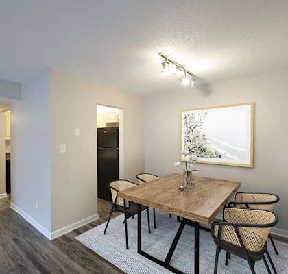A dining room with a wooden table and chairs.