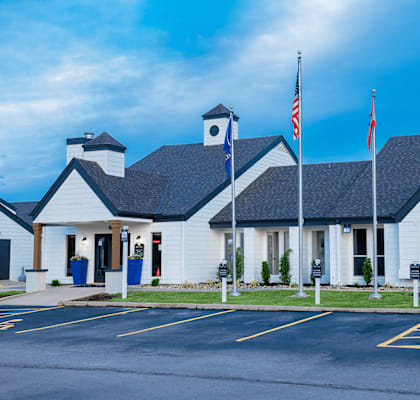 a white building with american flags and a blue mailbox