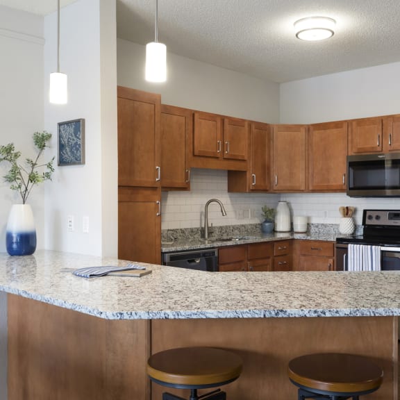 a kitchen with wooden cabinets and granite countertops