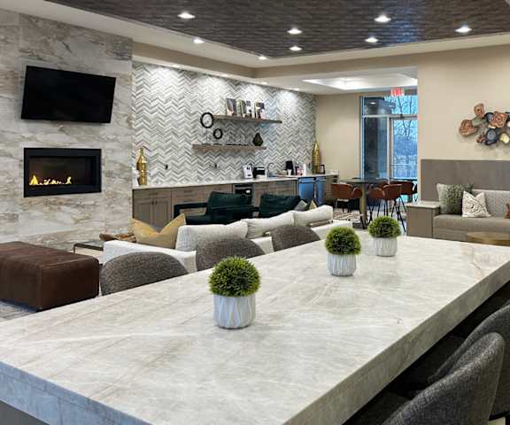 A modern dining room with a marble table and grey chairs.